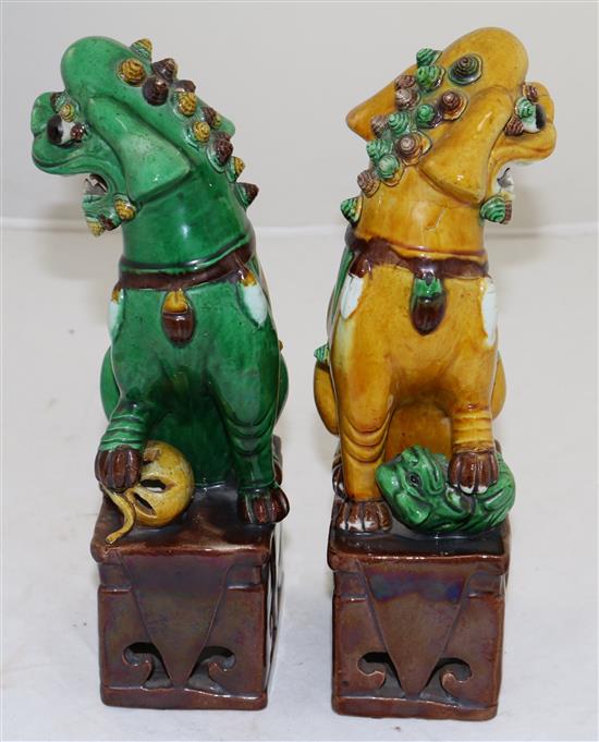 A pair of Chinese sancai glazed figures of Buddhist lions seated on plinths, 19th/20th century, 25cm